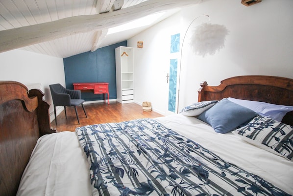 Un dormitorio con cama, escritorio y silla.