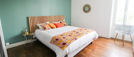Cozy retreat with a large bed, striped headboard, and a teal accent wall.