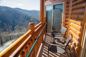 Enjoy a peaceful retreat with a view of the forested valley from the cabin's large window.