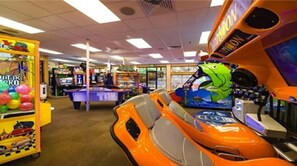 Experience the excitement of our arcade with a variety of games, a claw machine, and a racing game featuring a frog character.