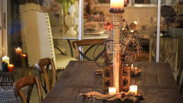 A dining table with candles, surrounded by chairs, in a room with a glass partition. - House on water canal, 5 minutes from downtown and beach. (Naples)