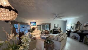 A spacious living room with a fireplace, comfortable seating, and a television. - House on water canal, 5 minutes from downtown and beach. (Naples)