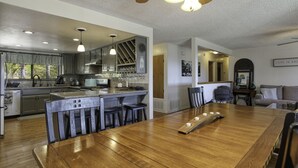 Eine geräumige Küche mit Holztisch, Bar und modernen Geräten.