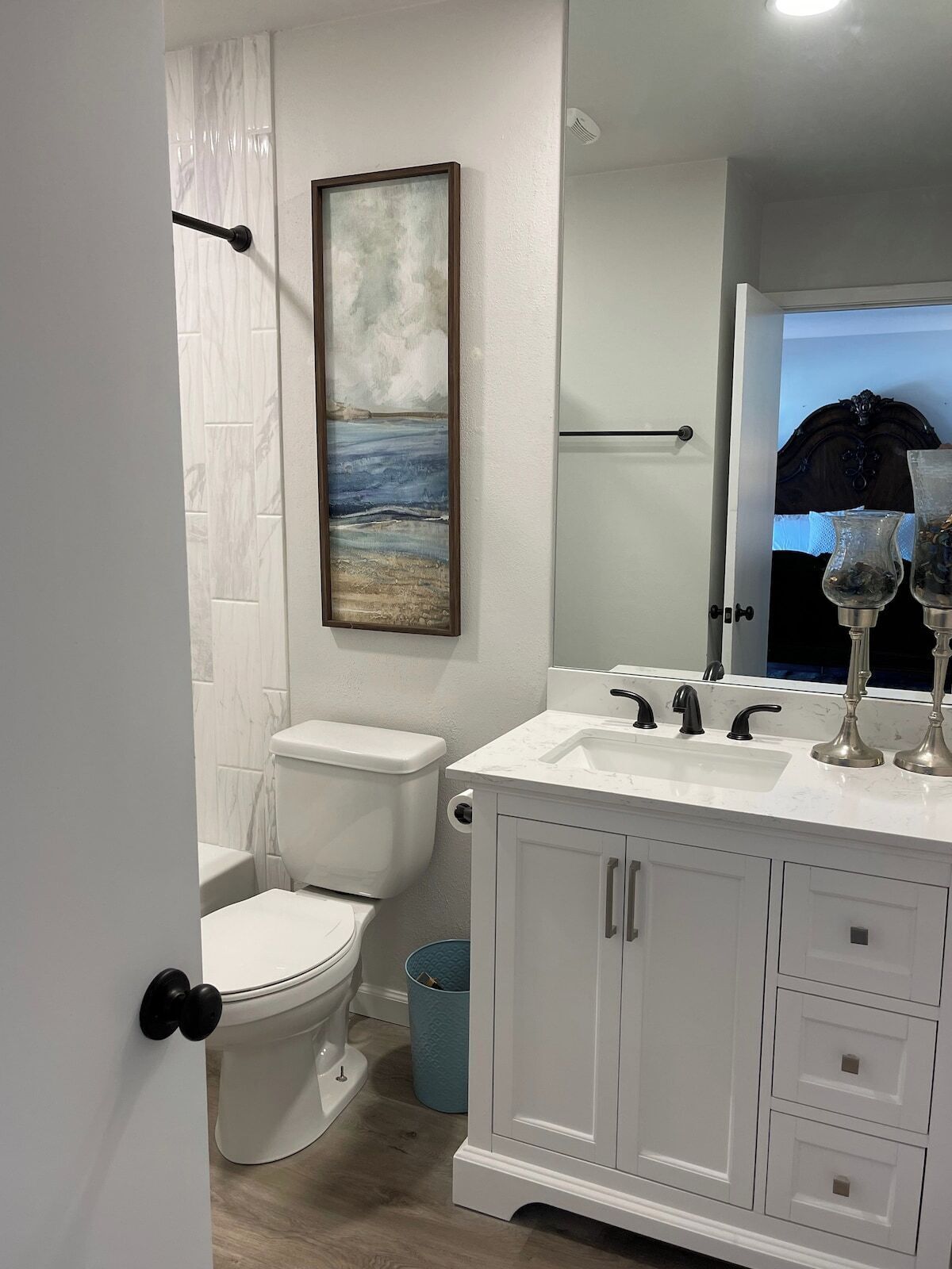 Ein Badezimmer mit Toilette, einem Waschbecken mit zwei Wasserhähnen und einem Schrank mit Schubladen.