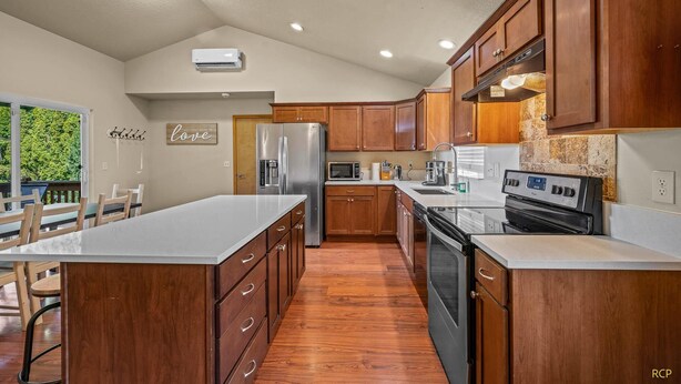 A modern kitchen with wooden cabinets, stainless steel appliances, and a large island. - Happy Valley Home, Game Room, & 8 beds! (Happy Valley)
