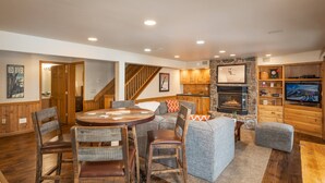 Un salón espacioso con chimenea, muebles de madera y televisor.