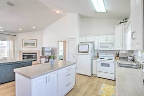 Cozy living area with a comfortable sofa and fireplace, complemented by a well-equipped kitchen with microwave, oven, and refrigerator.