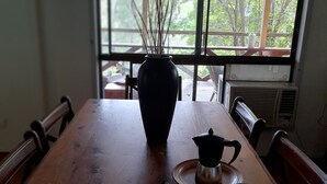 Una mesa de madera con un florero, una tetera y un plato de comida.