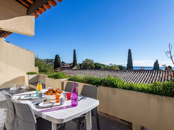 A table set outdoors with a view of a vineyard and distant buildings.