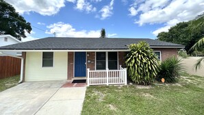 A single-story house with a front porch, a garage, and a small lawn.