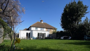 A two-story house with a tiled roof, a front porch, and a well-maintained lawn. - Seashells - 4 Bed - 2 Bath - Nr Beach - Sleeps 7 (Isle of Wight)