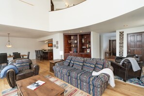 A spacious living room with a large sofa, a coffee table, and a dining area with chairs and a table. - Cozy Condo, Hot Tub, Pool, Hiking/Fishing Close! (Durango)