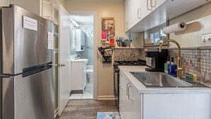 A modern kitchen with stainless steel appliances, a sink, and a tiled backsplash.
