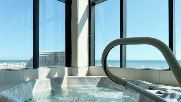 Un bain à remous avec vue sur l’océan, grâce à de grandes fenêtres.
