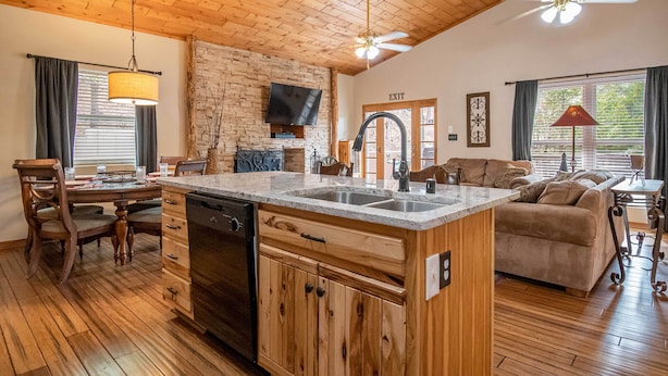 A spacious kitchen with wooden cabinets, a central island, and a dining area with chairs.