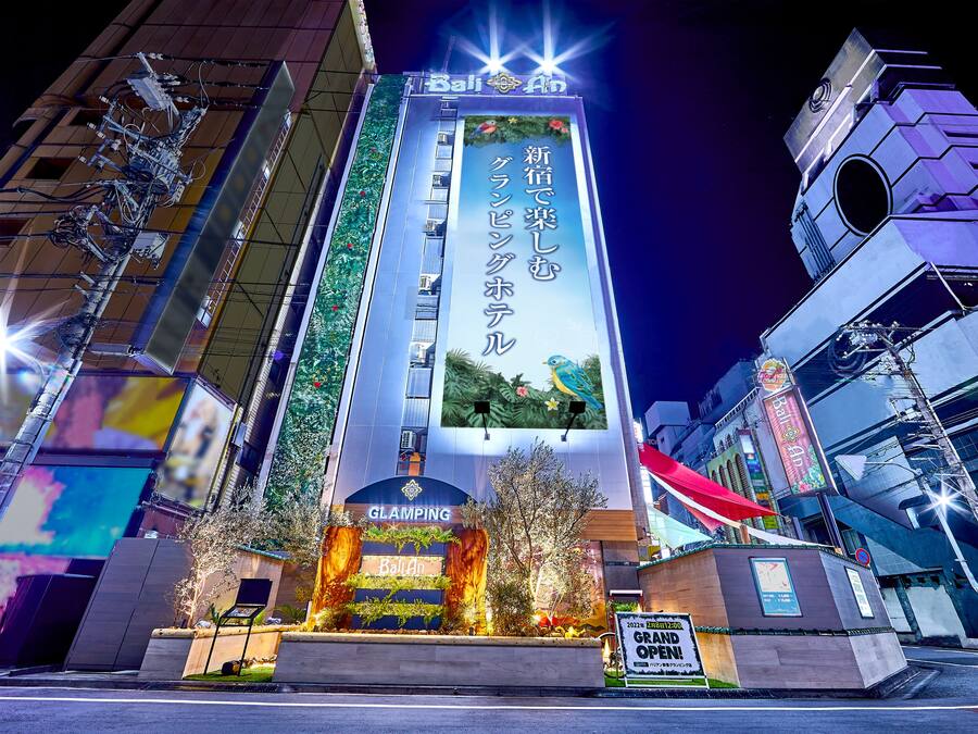 A hotel with a prominent sign, a landscaped entrance, and a modern architectural design.