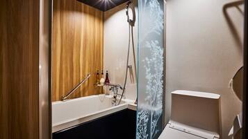 A modern bathroom with a wooden vanity, a white bathtub, and a glass shower enclosure.