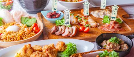 Variedad de platos, entre ellos arroz frito, sashimi y una ensalada.