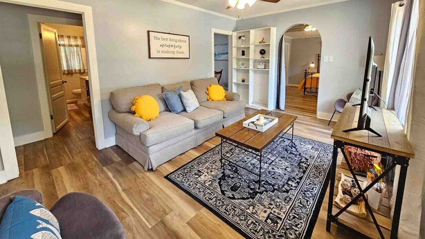 A living room with a sofa, coffee table, and a ceiling fan.