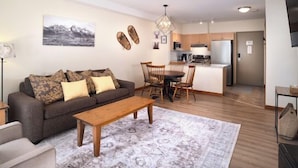 A living room with a sofa, coffee table, and patterned rug. - Beautiful 2 bedroom condo in the heart of the Rocky Mountains (Canmore)
