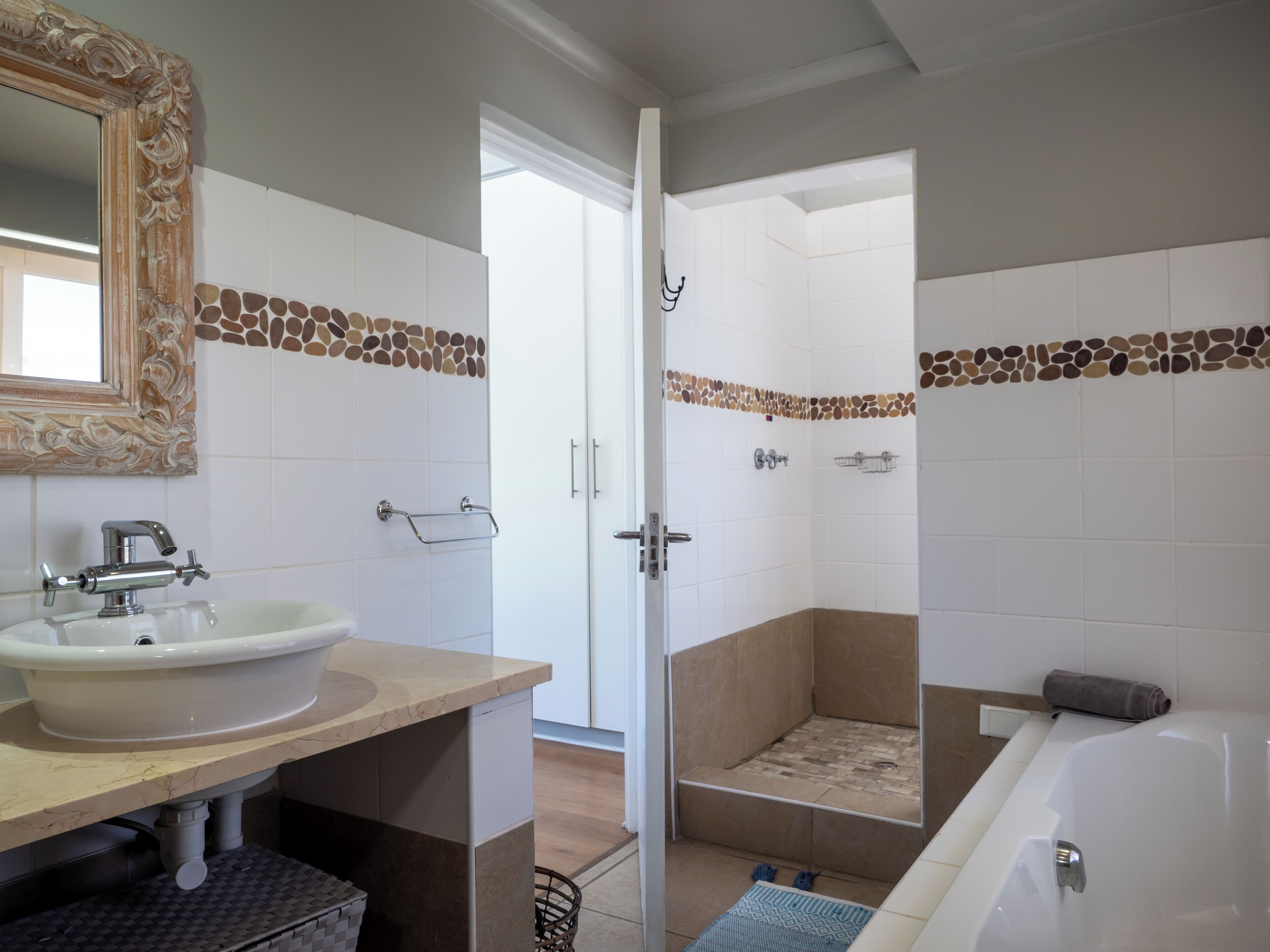 A bathroom with a sink, mirror, shower, and bathtub.