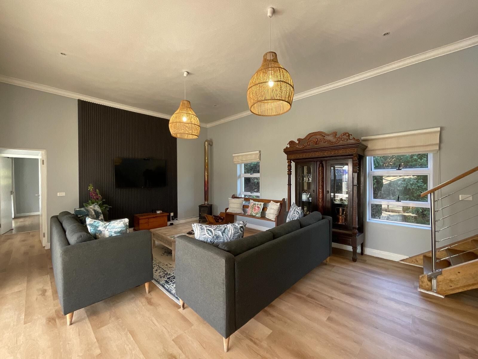 A spacious living room with a large sofa, a television, and a fireplace.