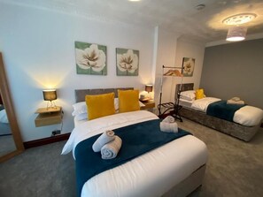Ein Hotelzimmer mit zwei Betten, einem Spiegel und Kunstwerken an den Wänden.