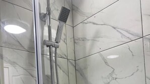 A glass-enclosed shower with a handheld showerhead and a wall-mounted control panel. - Cozy Swansea Apartment with 2 Bedrooms (Swansea)