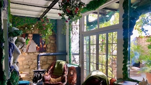 A cozy room with a stone wall, a large window, and a leather chair. - House Sleeps 4 with Private Garden (Mexilhoeira Grande)