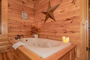 L’intérieur d’un chalet en bois, avec une grande baignoire, une décoration en forme d’étoile et un panneau indiquant : « Vivez simplement. »