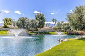 A landscaped area with a pond, fountains, and a well-maintained lawn. - Two King 👑 Suites,🌴Cozy Palm Desert Home Getaway ❤ 2 Great for Extended Stays! (Palm Desert)