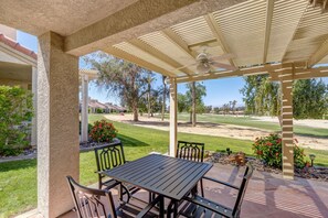 A covered patio with a table and chairs, overlooking a golf course. - Two King 👑 Suites,🌴Cozy Palm Desert Home Getaway ❤ 2 Great for Extended Stays! (Palm Desert)