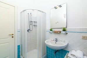 Ein Badezimmer mit Dusche, Waschbecken und Spiegel.