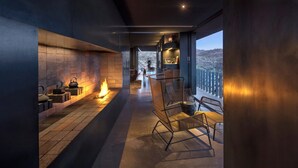 Ein modernes Interieur mit Kamin, Sitzgelegenheit und Blick ins Freie.