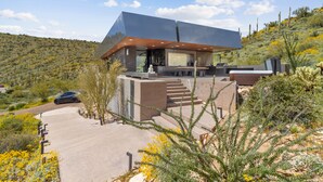 Ein modernes Haus mit flachem Dach, großen Fenstern und einer Terrassenfläche.