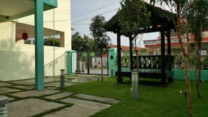 A courtyard with a gazebo, a small garden, and a building with a white facade and green accents. - Jonker Hijau-Hijau Malacca (Malacca City)