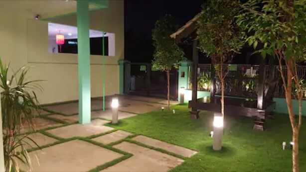 A nighttime view of a courtyard with a green lawn, a pathway, and a building with a window. - Jonker Hijau-Hijau Malacca (Malacca City)