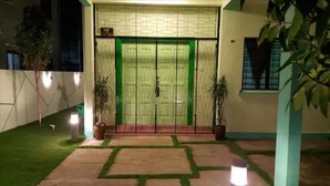 A building entrance with a double door, potted plants, and a paved pathway. - Jonker Hijau-Hijau Malacca (Malacca City)