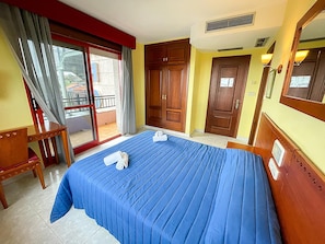 A hotel room with a bed, a desk, a chair, a balcony, and a door. - Hotel Acquamaris 3000 (Sanxenxo)