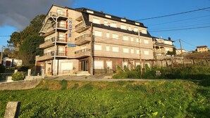 A multi-story hotel with a central staircase, balconies, and a sign indicating it is a hotel.