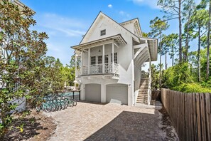 Une maison à deux étages avec un balcon, un garage et un escalier menant à l’étage supérieur.