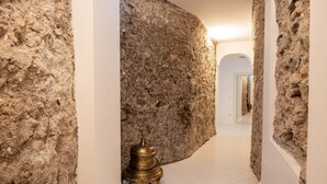 A hallway with a textured stone wall and a brass lamp. - Splendid luxury villa, an ancient palace in Amalfi with jacuzzi-pool and sea-view, at 300 m from the (Amalfi)