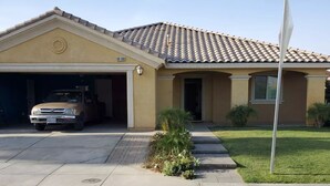 A residential house with a garage, a driveway, and a well-maintained lawn.