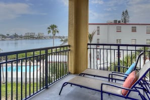 A balcony with a view of a pool and a cityscape. - Waterfront Views. Pool & Hot Tub, Great Beach Just Across the Street! Next to grocery store. (Treasure Island)