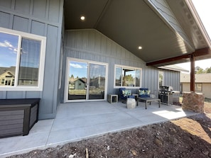Relax in style with a patio featuring comfortable seating, a grill, and a serene lawn view.