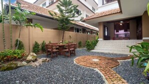 Zona residencial con un patio, una mesa de comedor y un camino de ladrillo.