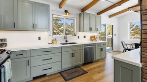 A modern kitchen with grey cabinets, a white countertop, and a wooden ceiling. - Mid Century Modern home in the boulders. Amazing views. 1 mile from downtown. (Prescott)