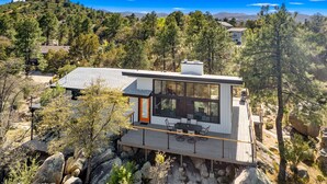 A modern house with a large glass window, a wooden deck, and a mountain view. - Mid Century Modern home in the boulders. Amazing views. 1 mile from downtown. (Prescott)