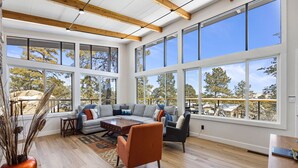A spacious living room with large windows, a wooden ceiling, and a modern sofa set. - Mid Century Modern home in the boulders. Amazing views. 1 mile from downtown. (Prescott)