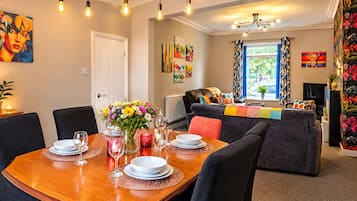 Comedor con mesa de madera dispuesta para cuatro personas, rodeada de sillas.